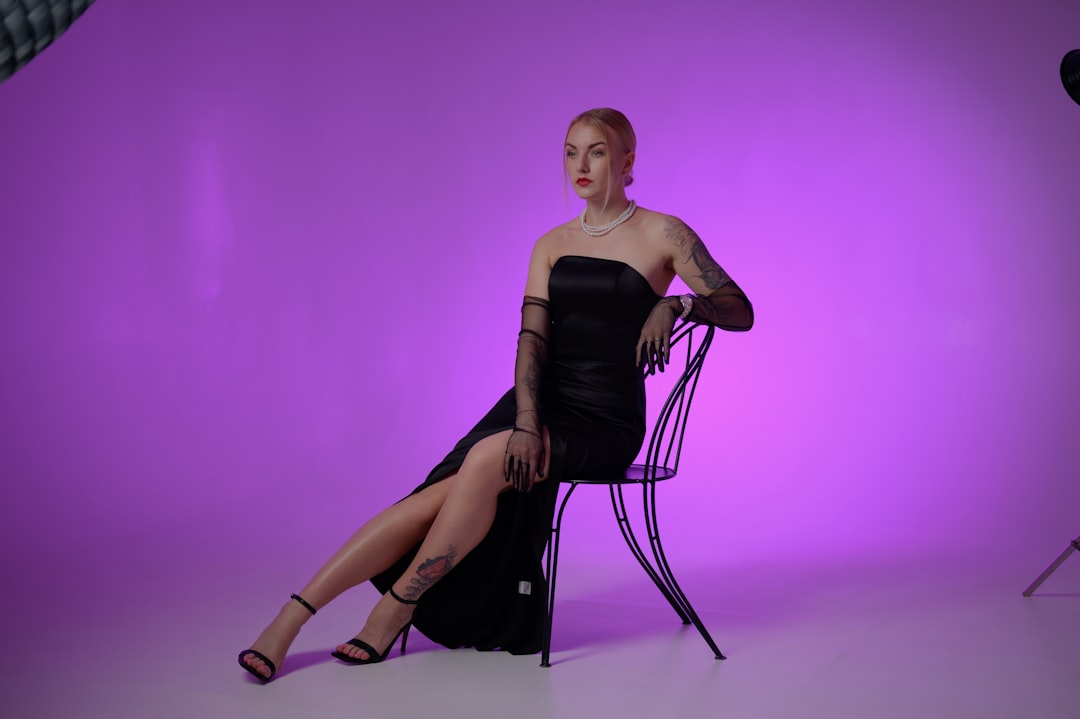 A woman poses in a black dress.