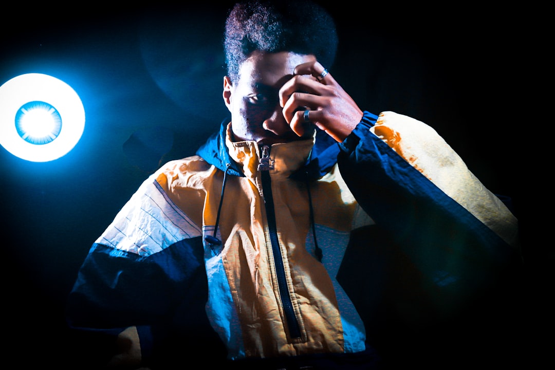 a man in a yellow and blue jacket holding a light