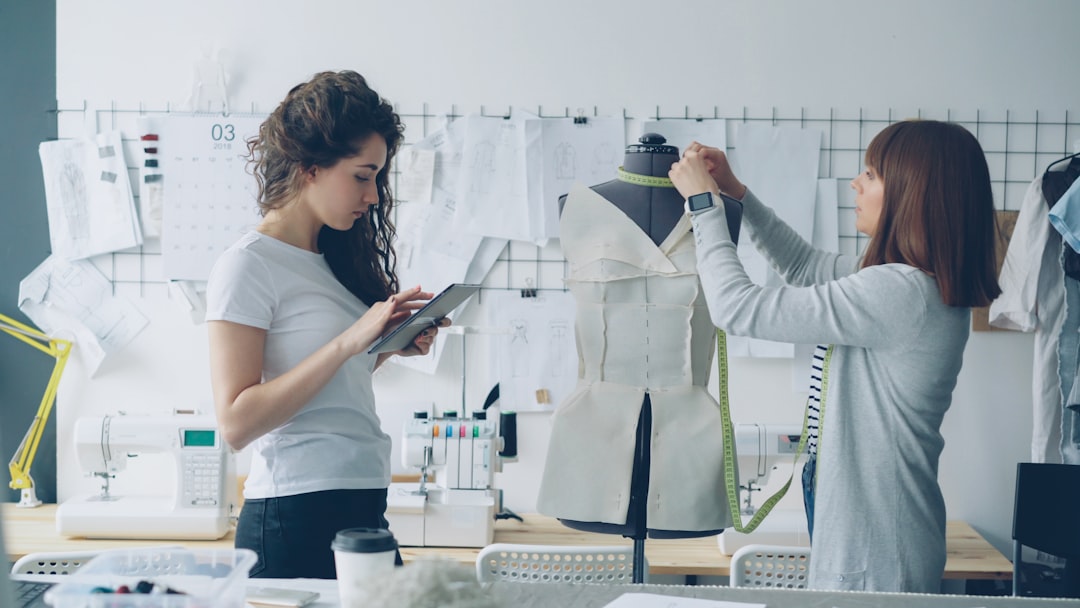 Fashion designers work on a dress in a studio.