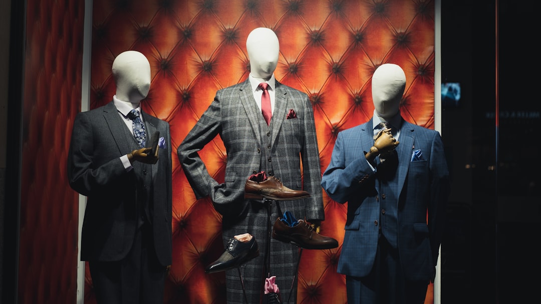 man in black suit standing near shoes