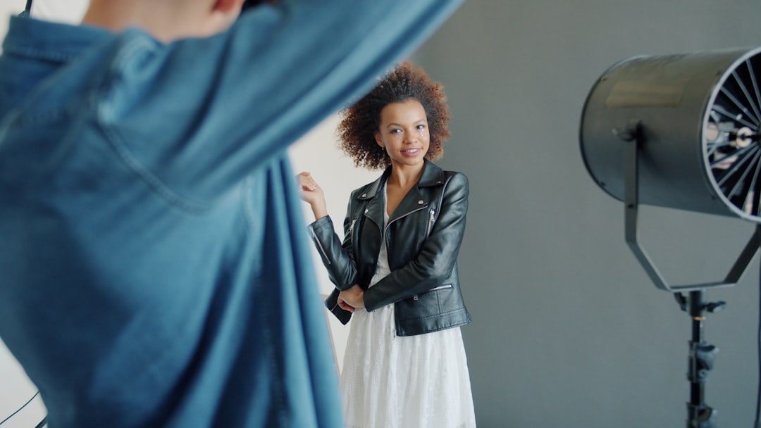 A woman poses in a studio with lighting equipment.